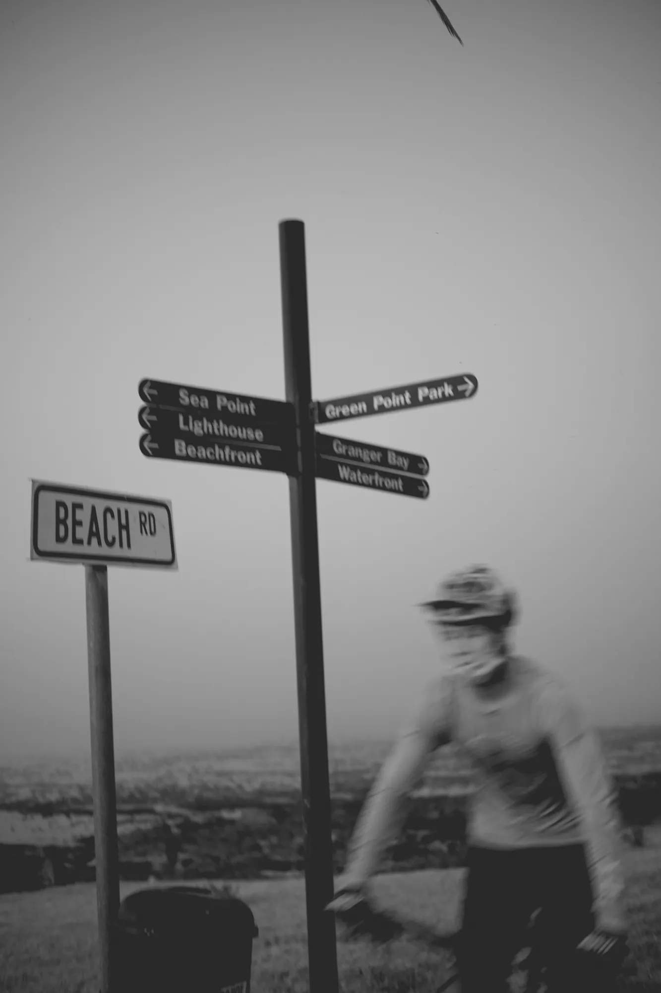 2022-02-15 - Cape Town - Man rides in front of sign that reads 'Beach Road'